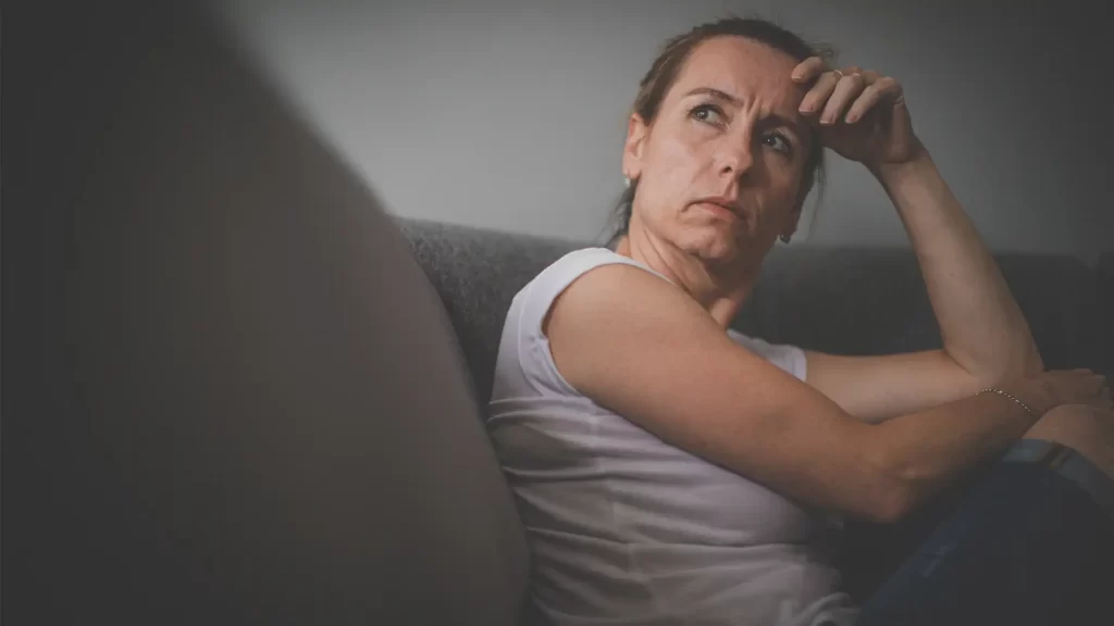 långtidsarbetslös kvinna sitter hemma i sin soffa