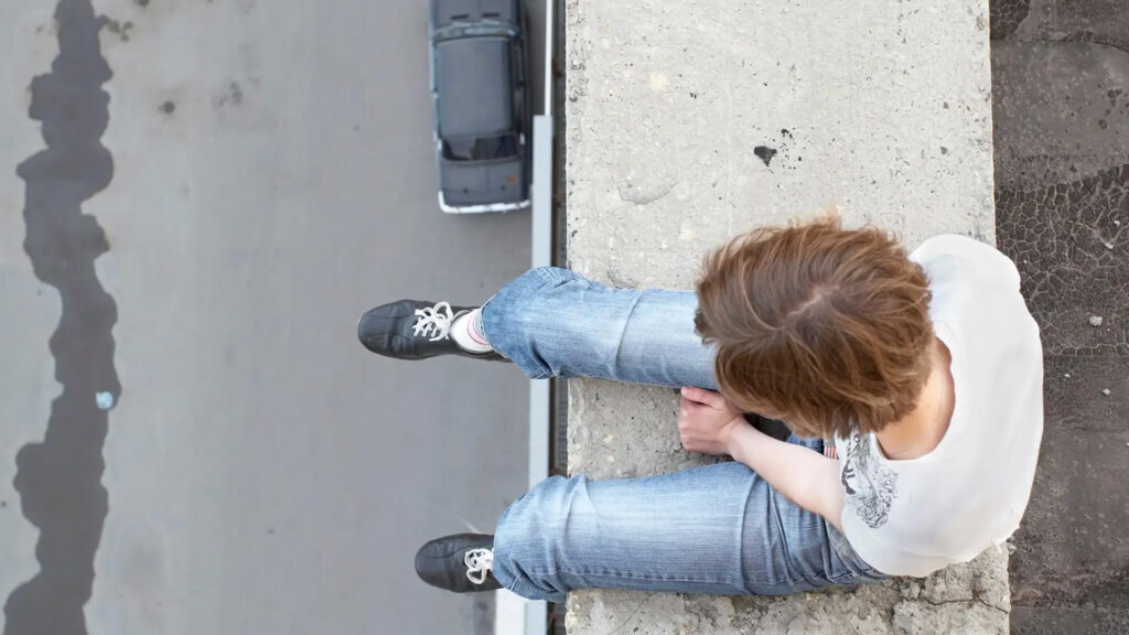 Kvinna sitter på kanten på gränsen att hoppa