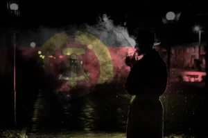 Spion i svartvitt mörk gata med östtysk flagga i bakgrunden