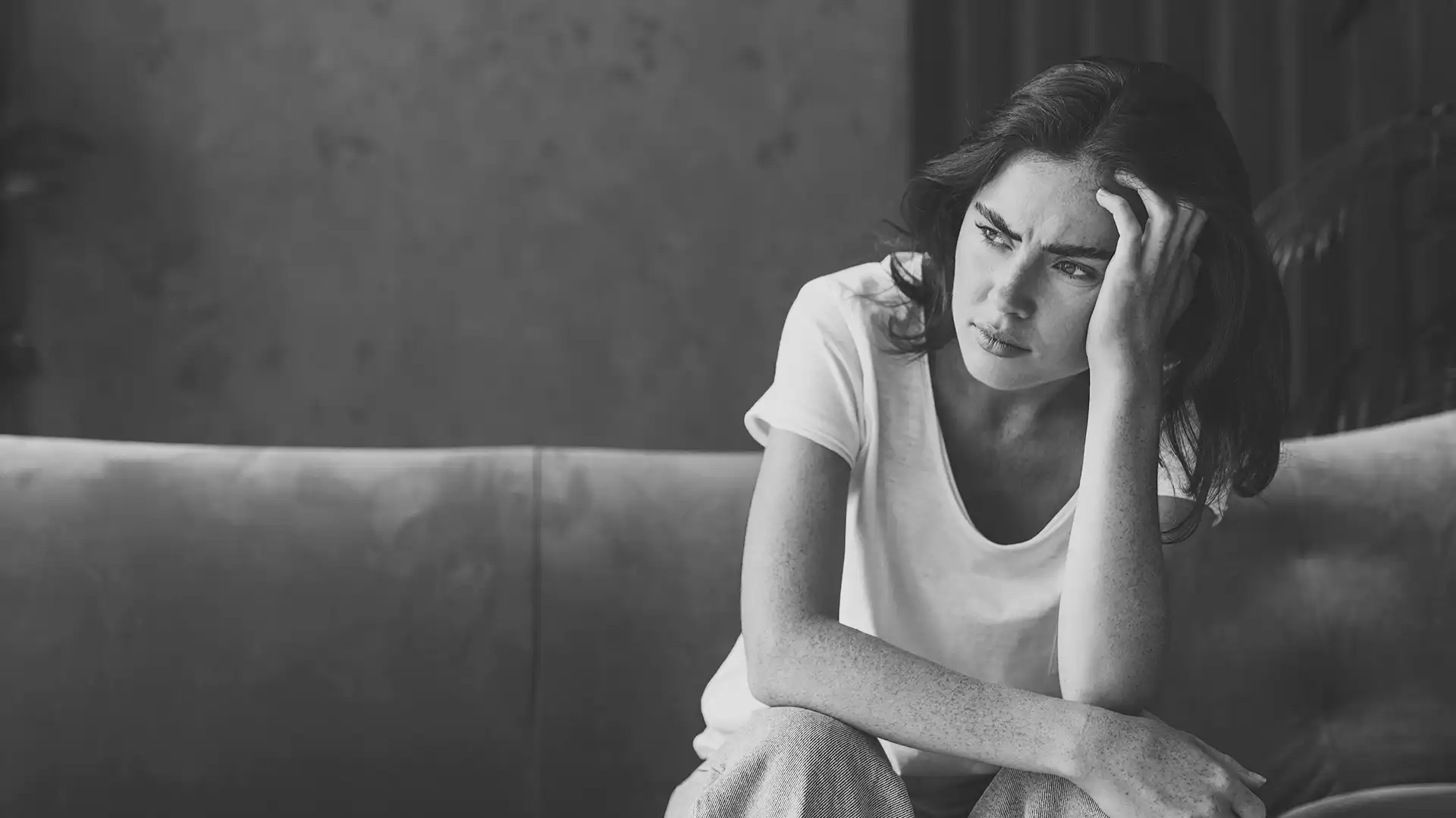 Kvinna sitter i soffan besviekn över beslut från IVO