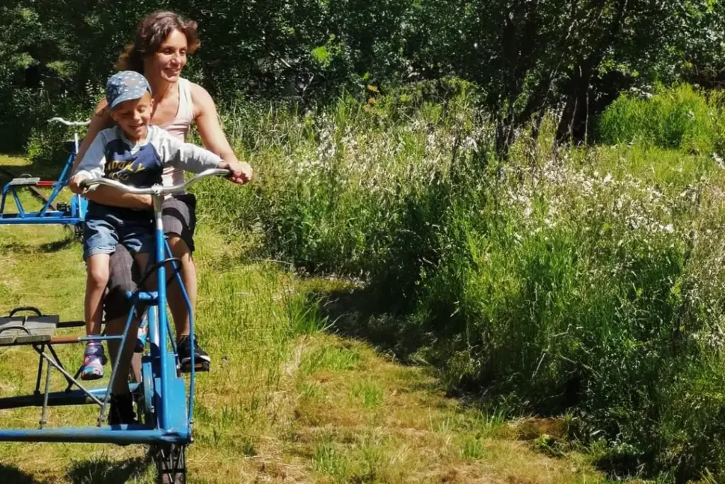 Mamma och barn åker på en Dressin en vacker sommar dag