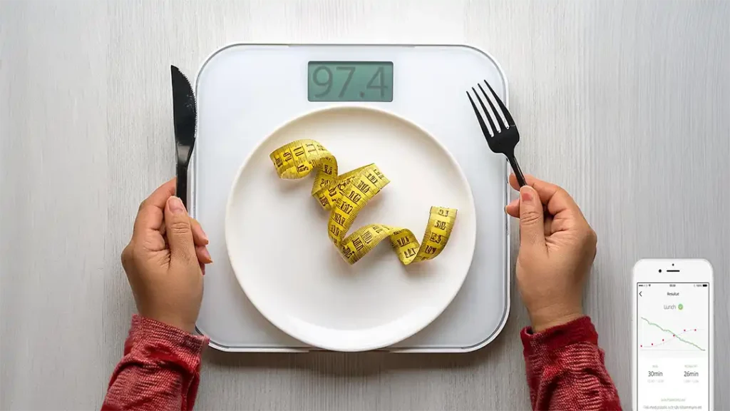 tallrik står på en våg och ett måttband på tallriken