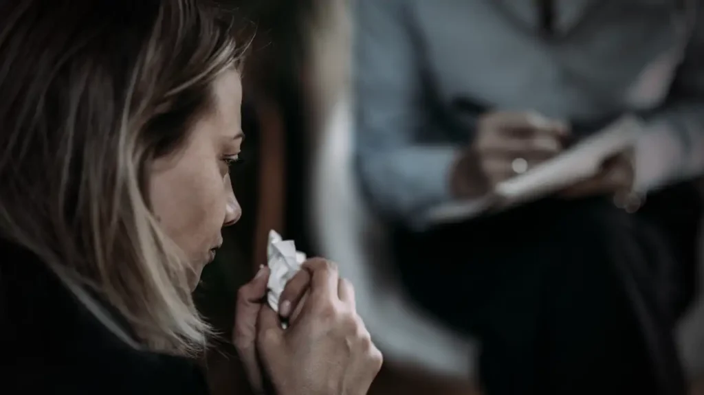 Kvinna sitter hos sin psykolog har en näsduk i sin hand