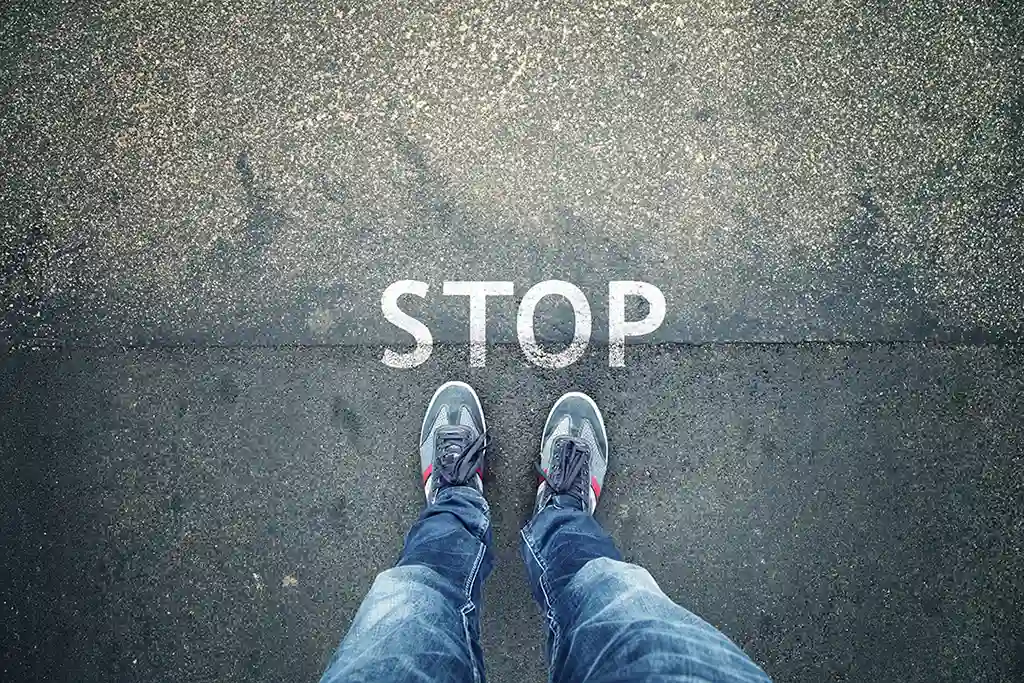 Foto ovanifrån, asfalterad väg med texten stop, två